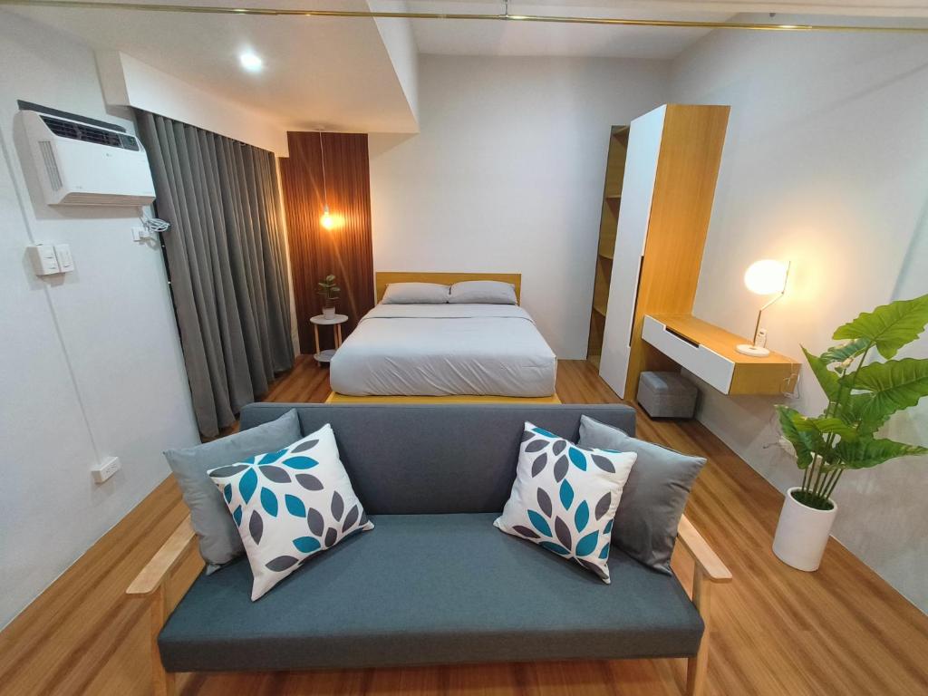 ein Schlafzimmer mit einem Bett und einem Sofa in einem Zimmer in der Unterkunft ZSL Elegant Condo LOOP Tower 1 in Cagayan de Oro