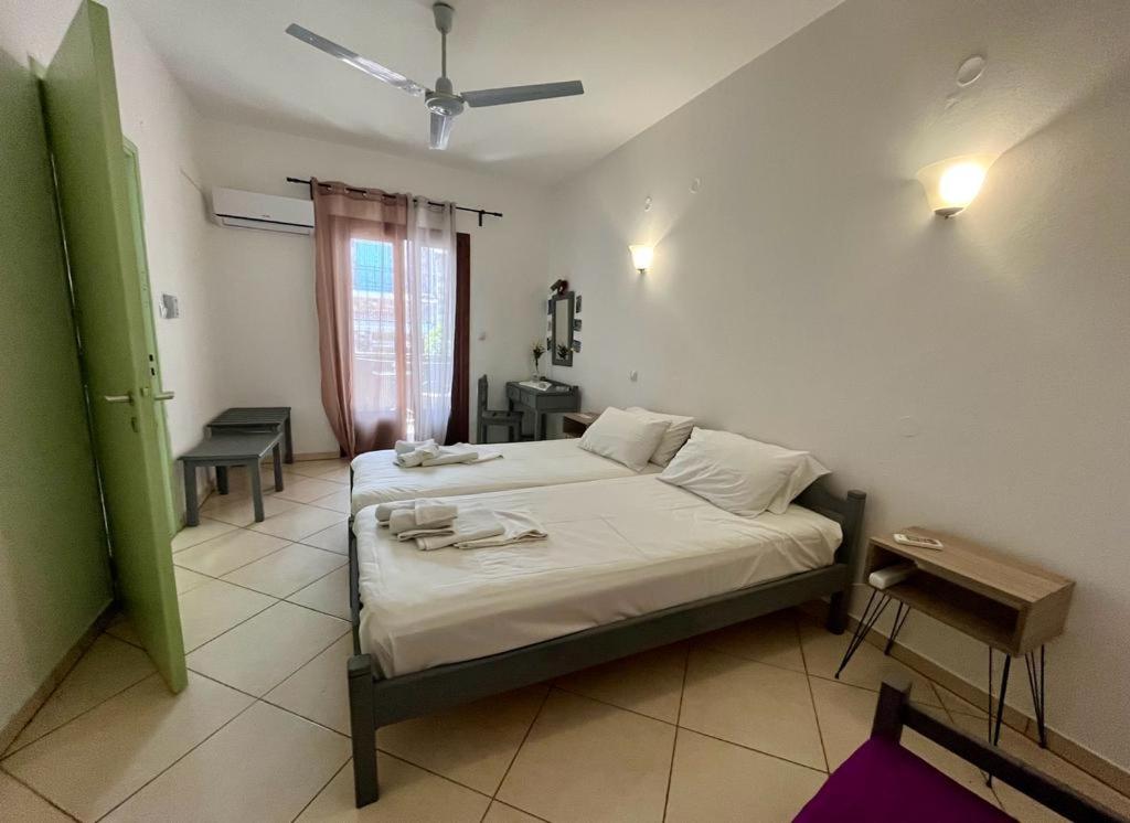 Schlafzimmer mit einem Bett, einem Tisch und einem Fenster in der Unterkunft Samos - Kokkari - Eirini's Studios in Kokkari