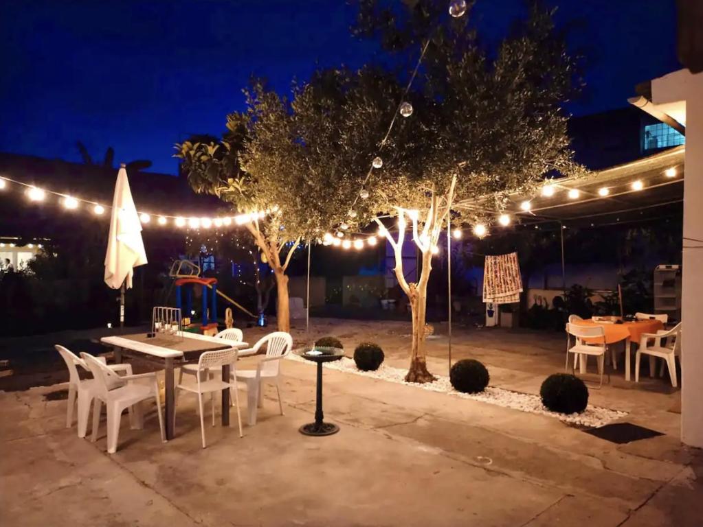 a patio with a table and chairs and lights at Casa Silva Diamond in Pinhal Novo