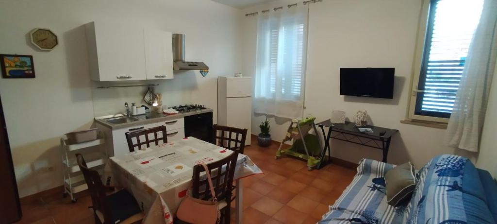 een keuken met een tafel en stoelen en een keuken met een fornuis bij Mondello Blue Sea in Mondello
