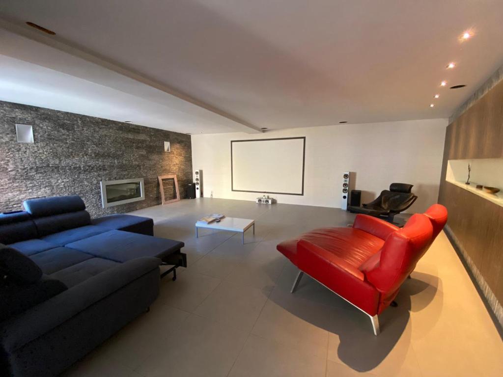 Loft في أنتويرب: غرفة معيشة مع أريكة زرقاء وكرسي احمر