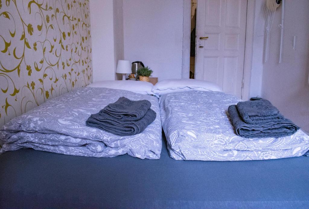 two beds in a room with towels on them at Artsy Room for 2 in Prenzlauer Berg - Ideal Stay in Shared Flat in Berlin