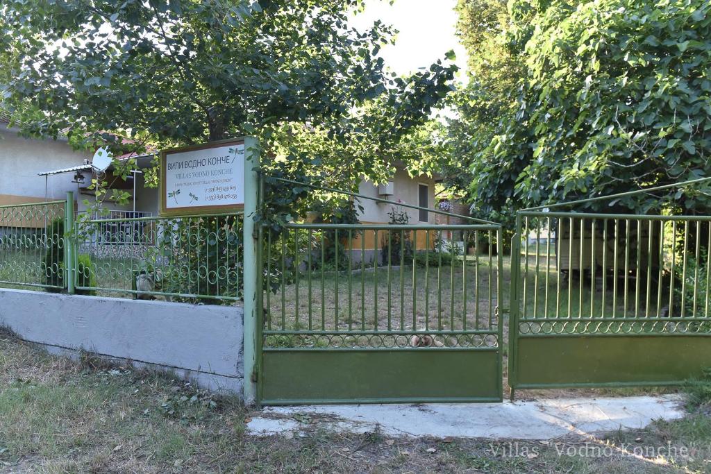 a green metal gate with a sign on it at Вили Водно Конче Villas Vodno Konche in Ahtopol