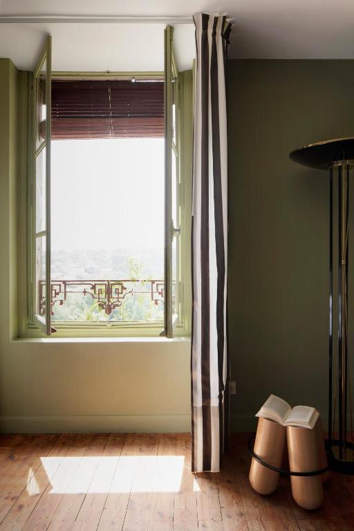 a living room with a window and a pair of shoes at Au Petit Thouars in Thouars