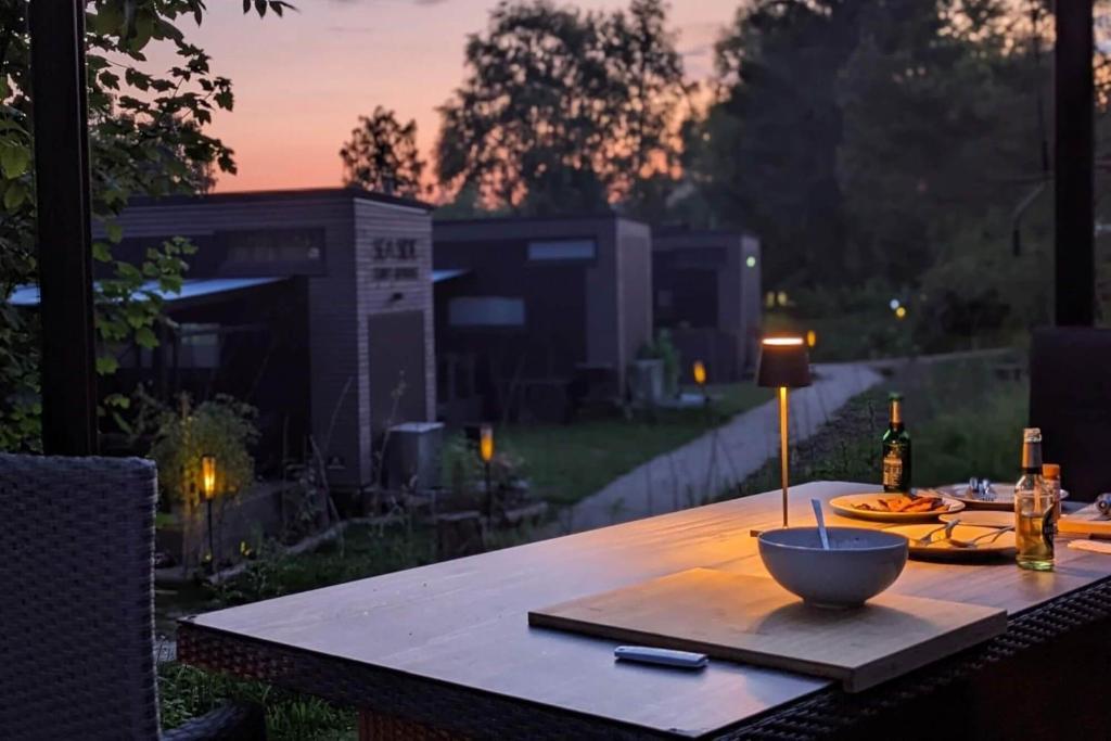 a wooden table with a bowl on top of it at Tiny House Ithblick direkt am See in Salzhemmendorf