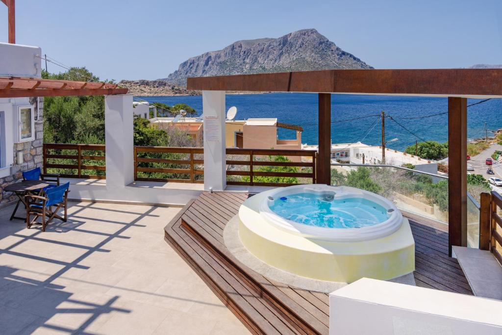 a hot tub on a deck with a view of the ocean at Vasilis Studios Family House in Kalymnos