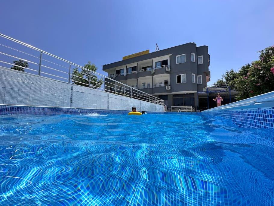 a large blue swimming pool with a person in it at Olympos Likya Apart Otel in Yenbey