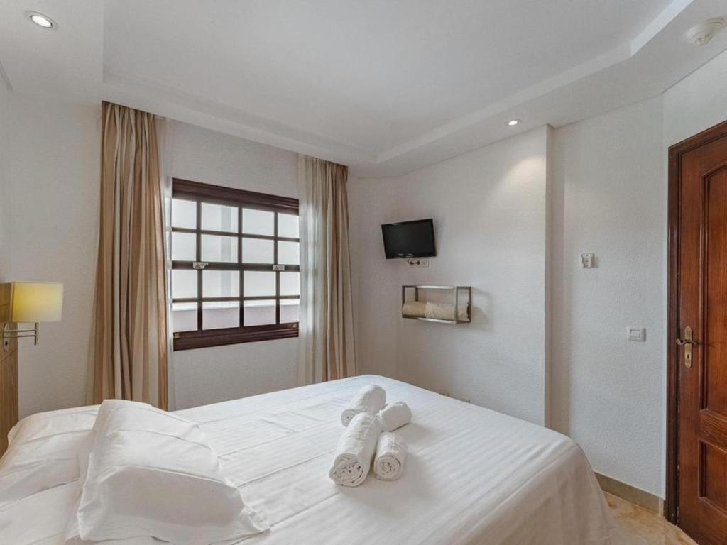 a white teddy bear sitting on top of a bed at 349 Apartamento Golf del Sur Albatros in San Miguel de Abona