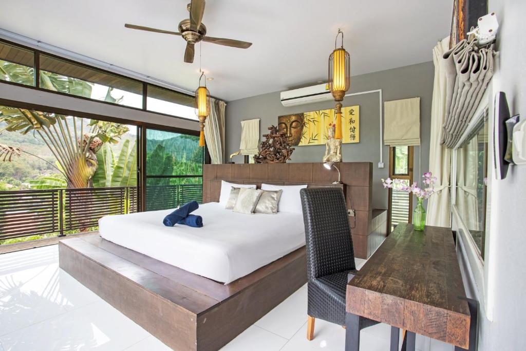 a bedroom with a large bed and a desk at Luxury 6BR Pool Villa Oxavia next to NaiHarn Beach in Rawai Beach