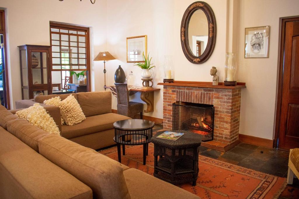 sala de estar con sofá y chimenea en 5 Seasons Guest House, en Stellenbosch