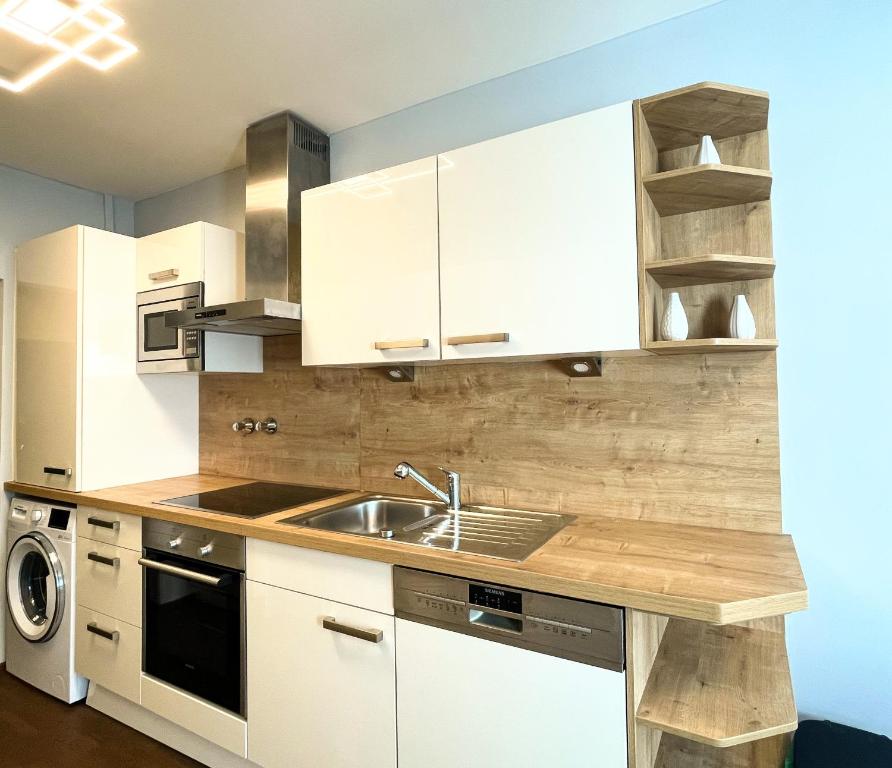 a kitchen with white cabinets and a sink at Vienna's Central Gem: Artistic Apartment in the Heart of the City in Vienna