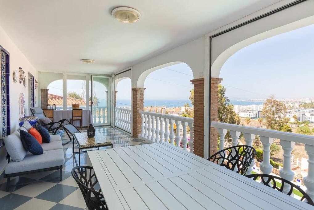 a porch with a table and chairs on a balcony at Villa María con Piscina playa y vistas in Caleta De Velez