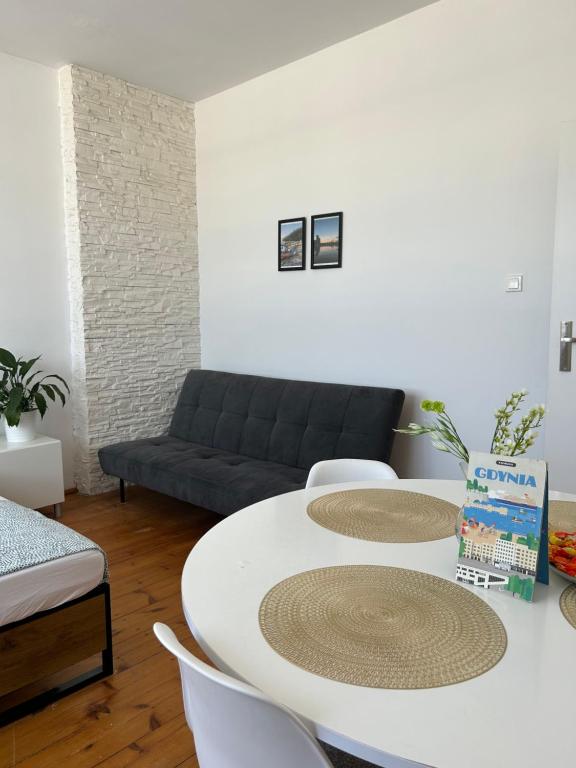 uma sala de estar com uma mesa branca e um sofá em Sunhaus em Gdynia