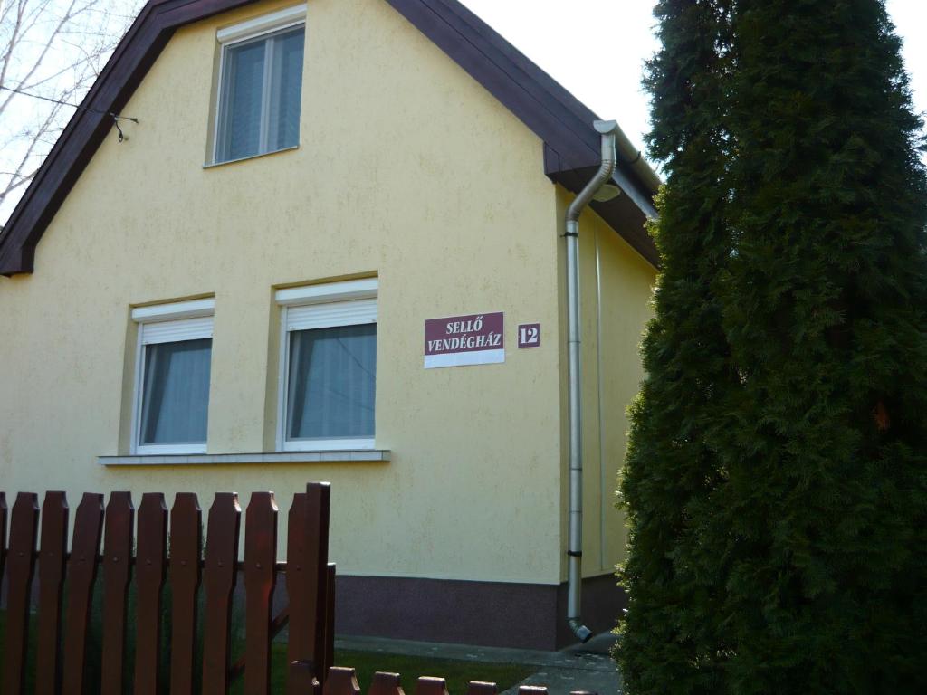 a house with a sign on the side of it at Holiday home Sellő Vendégház in Tiszafüred
