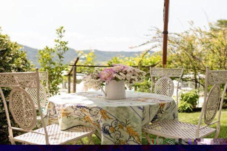 una mesa y sillas con un jarrón de flores. en Cozy apartment in a farmhouse in Camino Ombra, en Camino