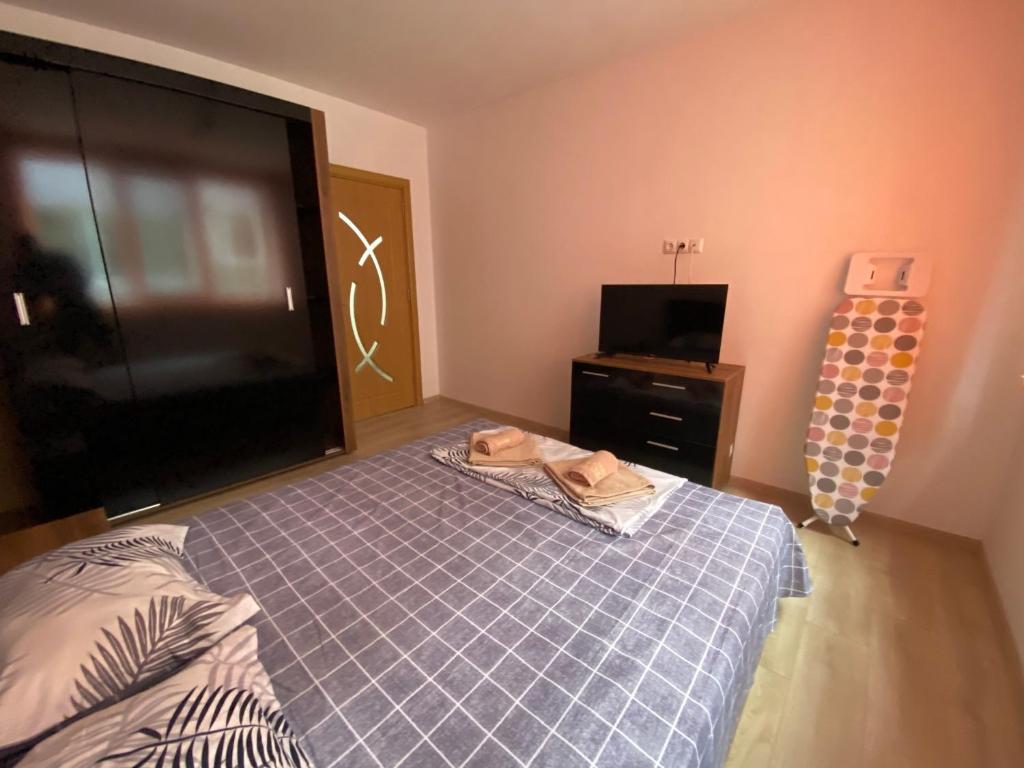 um quarto com uma cama e uma televisão de ecrã plano em Apartamenti Eli em Pomorie