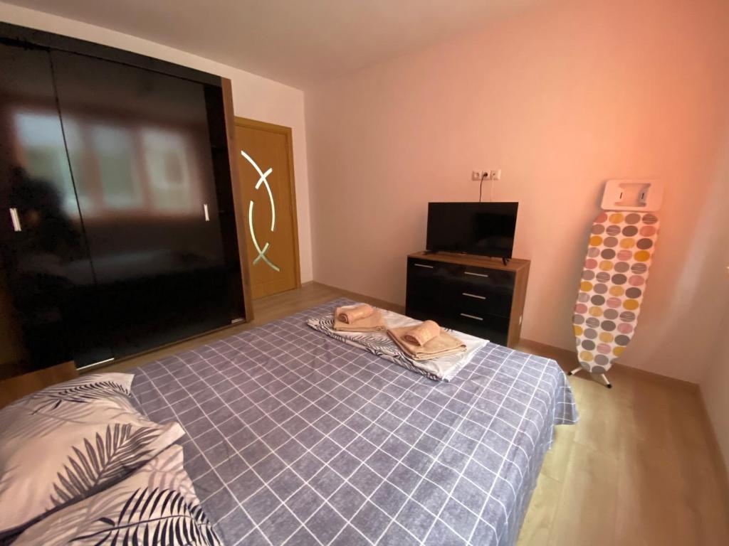 a bedroom with a bed and a flat screen tv at Apartamenti Ely in Pomorie