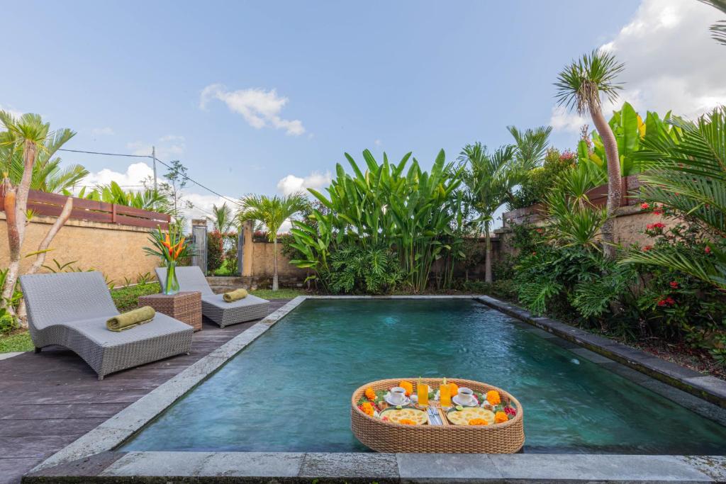 una piscina con una barca giocattolo al centro di NILUH Private Villas ad Ubud