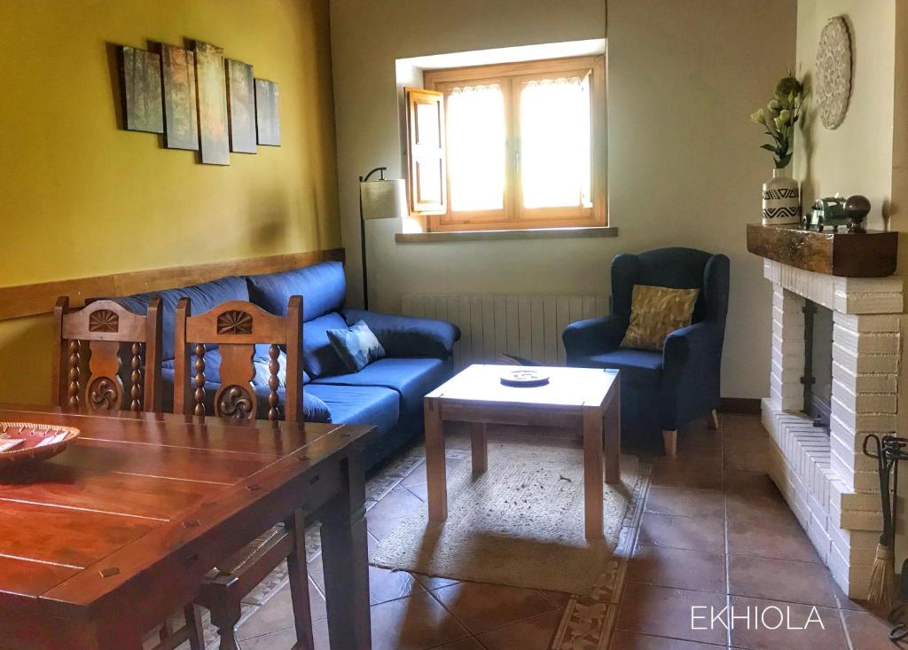 a living room with a blue couch and chairs at Ekhiola in Ochagavía
