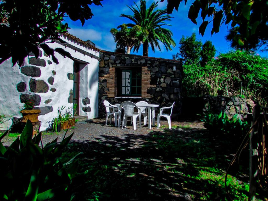 une maison avec une table et des chaises devant elle dans l'établissement La Bodega casa rural con piscina y jardines, à Breña Baja