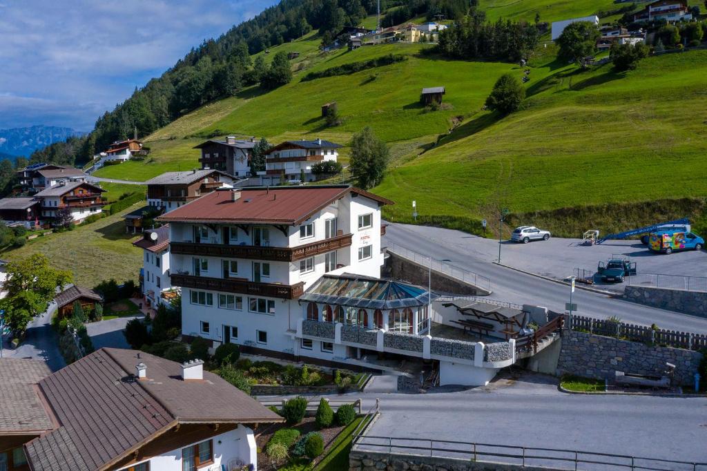 a large white building in a village with a hill at Pitztal Living in Jerzens