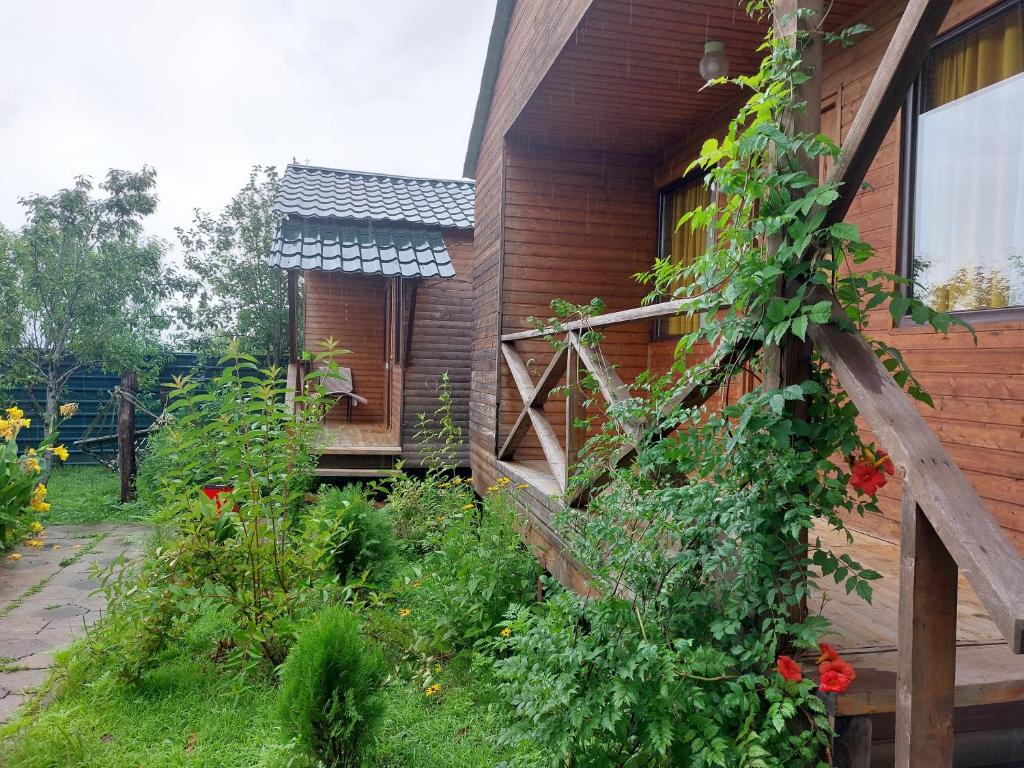 een huis met een hek en een tuin met bloemen bij sweet village in Tskaltubo