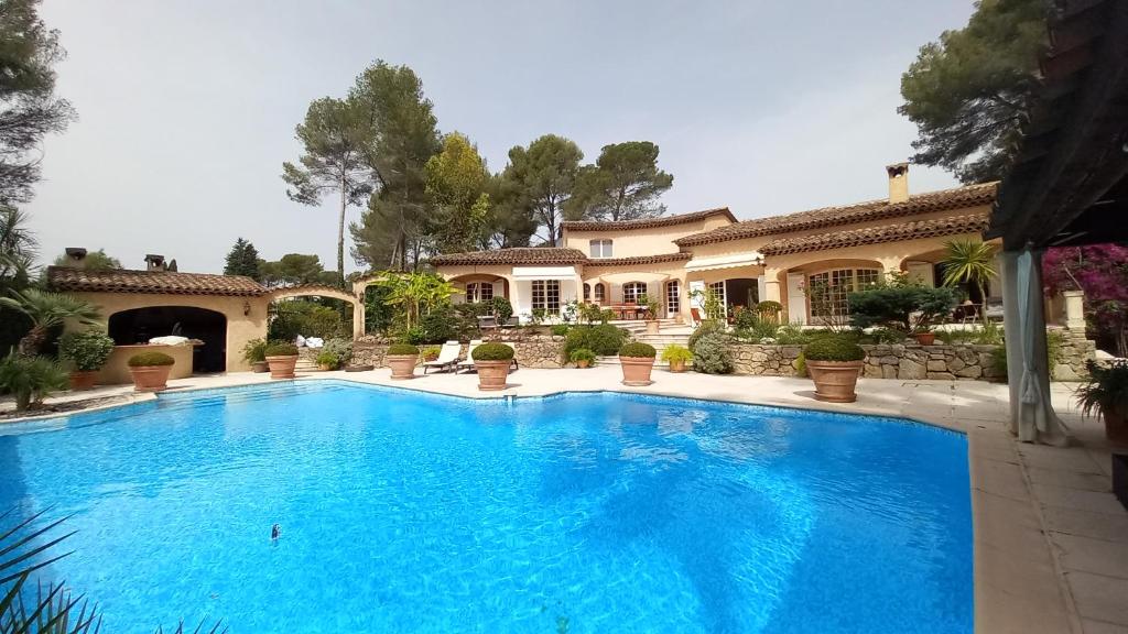 une grande piscine devant une maison dans l'établissement Villa Parc Saint-Martin, à Mougins