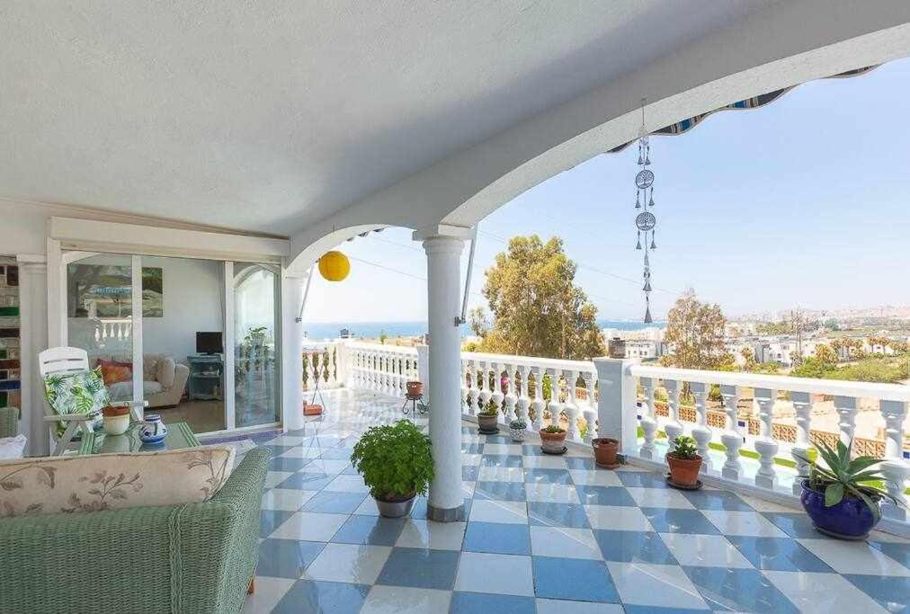 a house with a balcony with potted plants on it at Caleta del Sol con piscina terraza y playa in Caleta De Velez