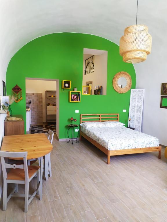 a green bedroom with a bed and a table at La casetta di Carmela in Naples