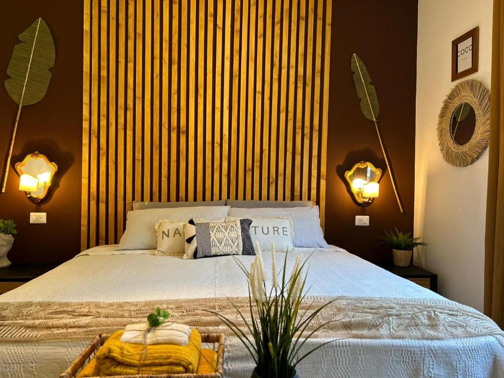 1 dormitorio con 1 cama grande y 2 luces en TROPICAL HOME PORTO CERESIO en Porto Ceresio