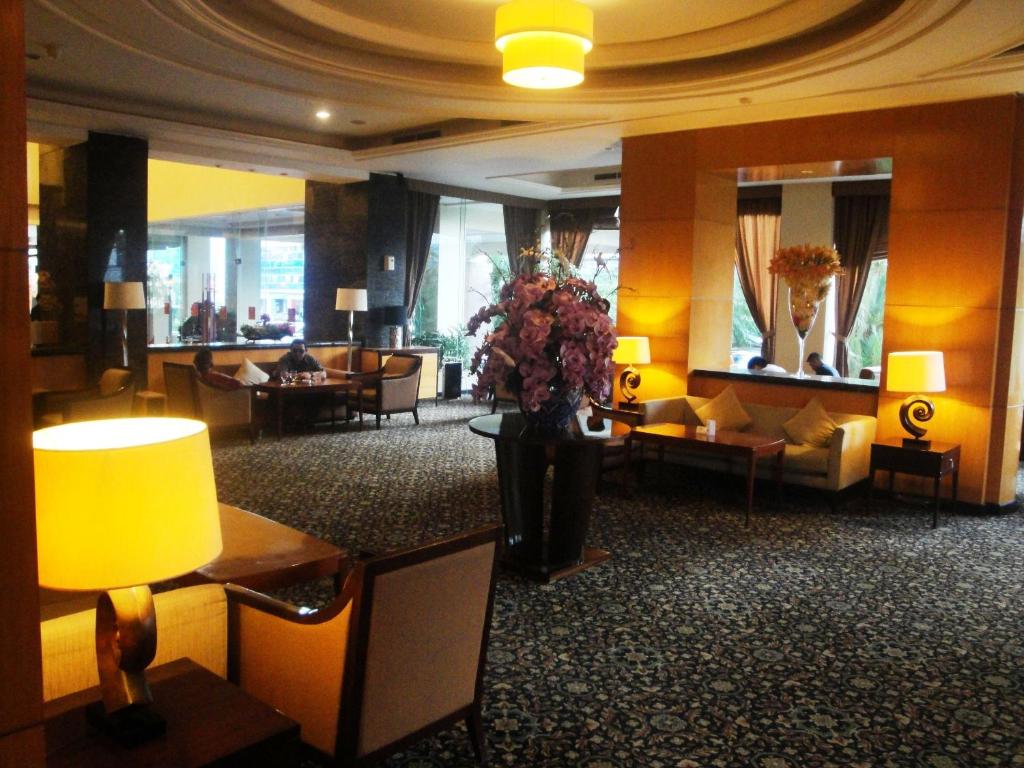 eine Lobby mit Sofas und einer Vase aus Blumen in der Unterkunft Manado Quality Hotel in Manado