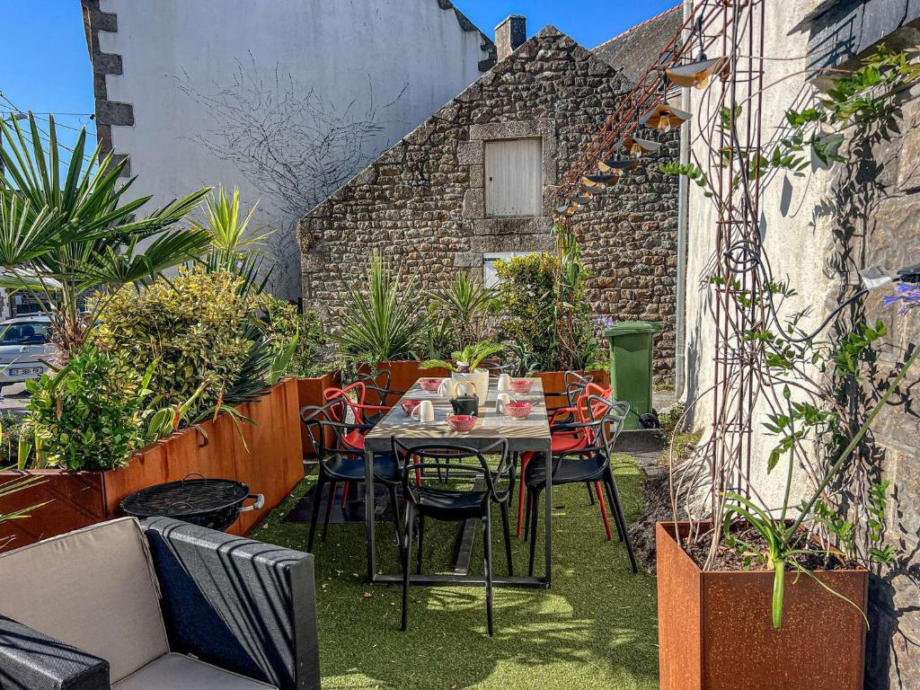 einen Tisch und Stühle auf einer Terrasse mit Pflanzen in der Unterkunft Villa Belz, 3 pièces, 2 personnes - FR-1-479-142 in Belz