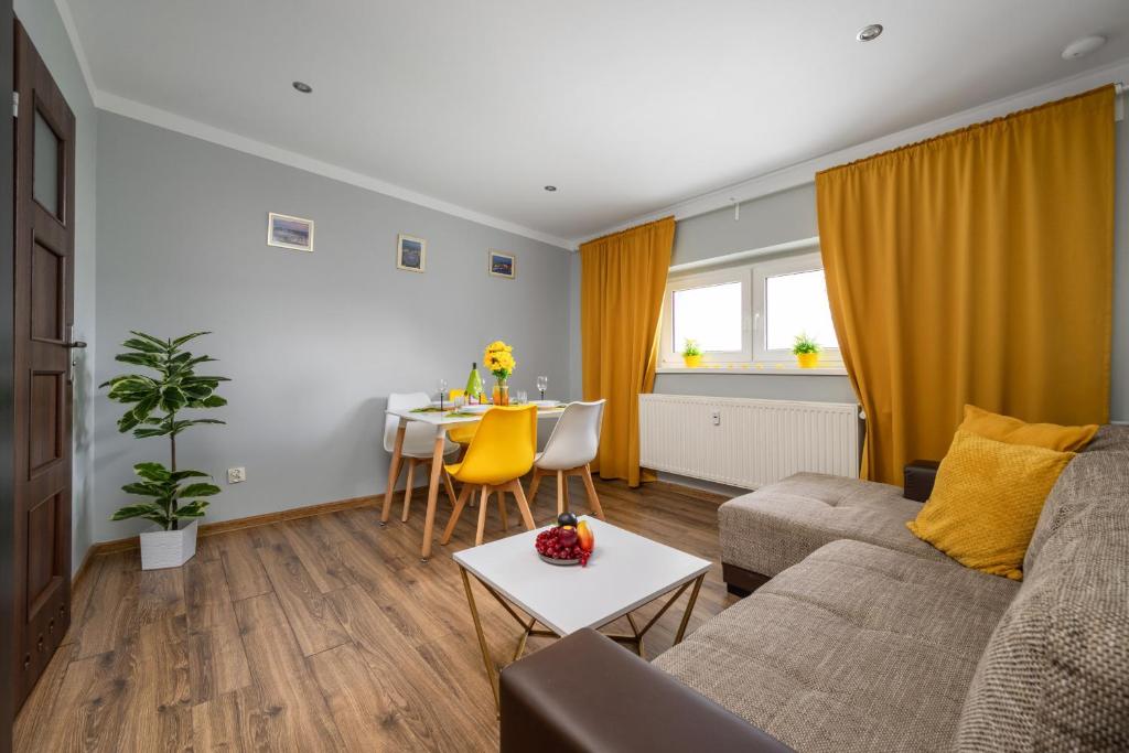 a living room with a couch and a table at Market Square Corner Apartment Kuźnicza by Renters in Wrocław