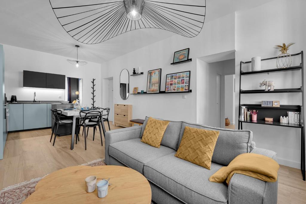 un salon et une cuisine avec un canapé et une table dans l'établissement L'Azzurri - Charmant appartement pour 4, à Toulouse