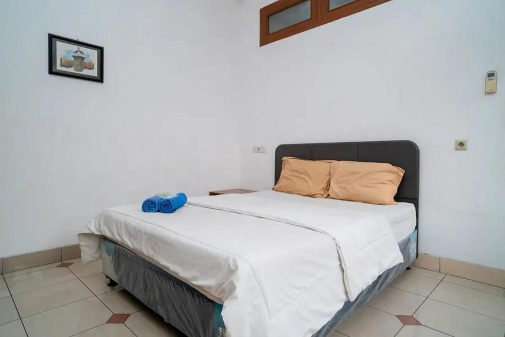 een slaapkamer met een groot bed met witte lakens bij Puri Saras Bintaro Syariah Mitra RedDoorz in Jurangmanggu