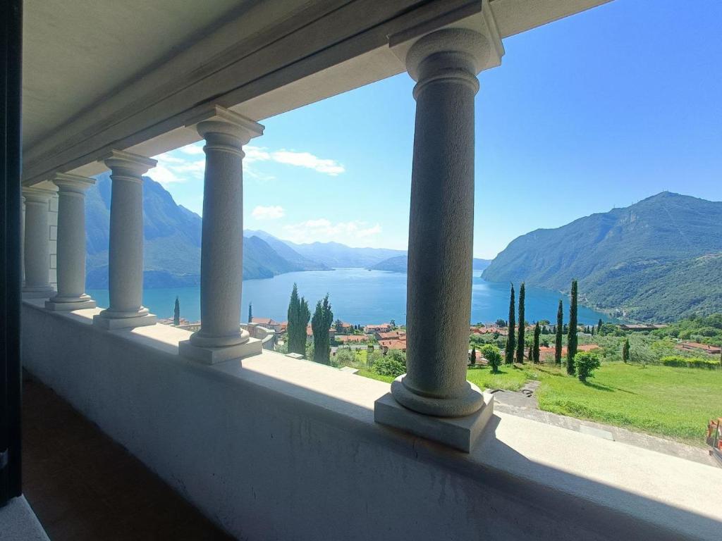 a balcony with a view of the water and mountains at Villa Hélène in Solto Collina