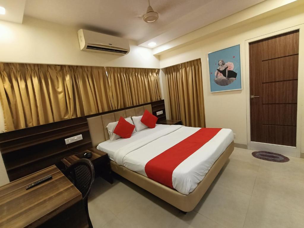 Habitación de hotel con cama, escritorio y cama sidx sidx en Payal Hotel Panvel en Navi Mumbai