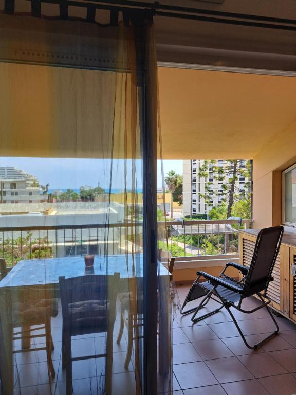 un salon avec une table et des chaises et un balcon dans l'établissement Mon jardin, à Villeneuve-Loubet