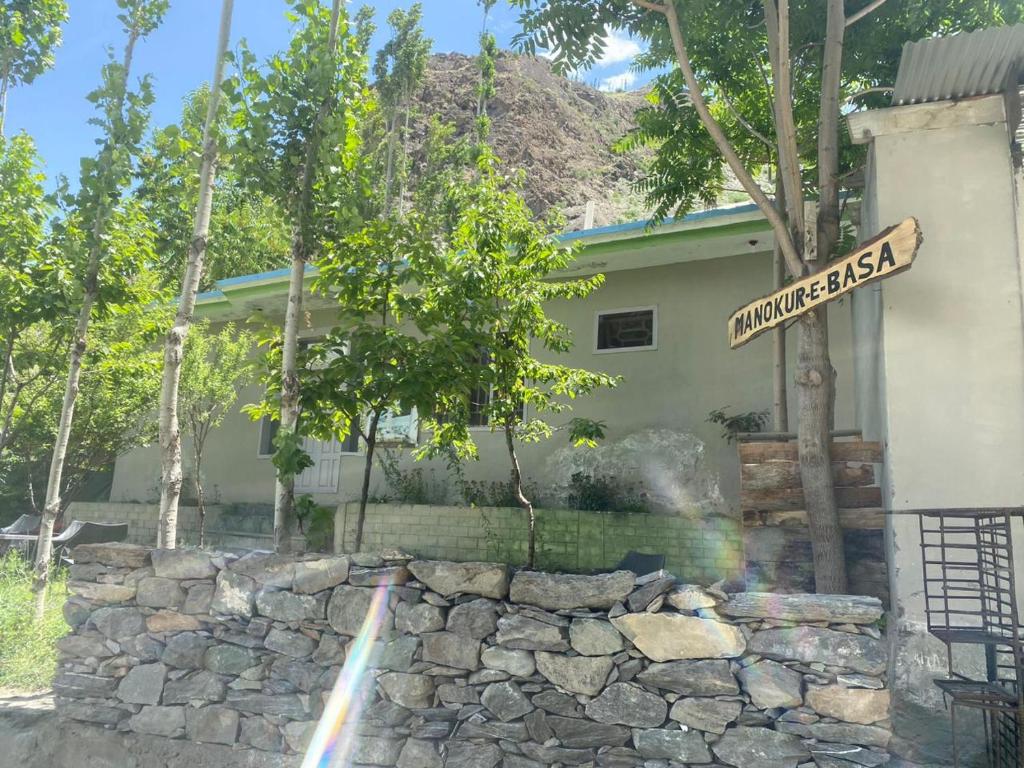 un letrero de la calle frente a un edificio con una pared de piedra en MANOKUR - E- BASA HOTEl, en Minapin