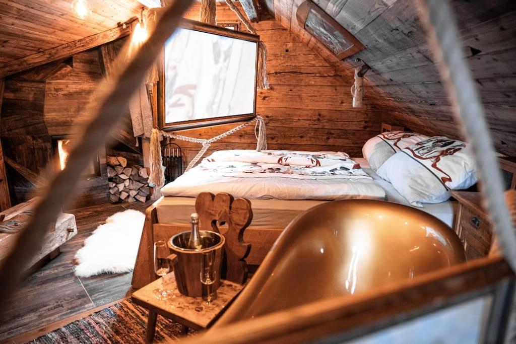 a room with a bed and a tub in a cabin at Troadkasten - Nationalpark Kalkalpen in Ramsau