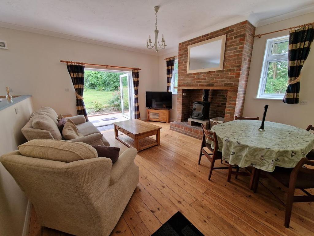 a living room with a table and a fireplace at Country retreat near sea and South Downs, on National Cycle Network in Polegate
