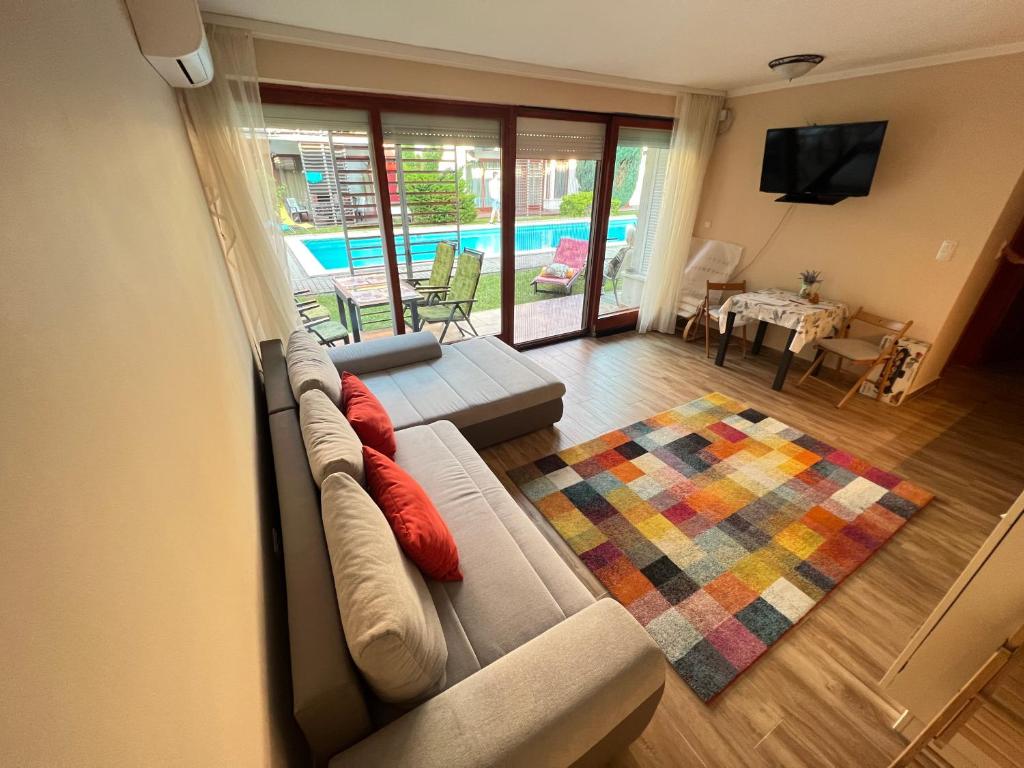 a living room with a couch and a television at Gold Sea Apartman in Siófok