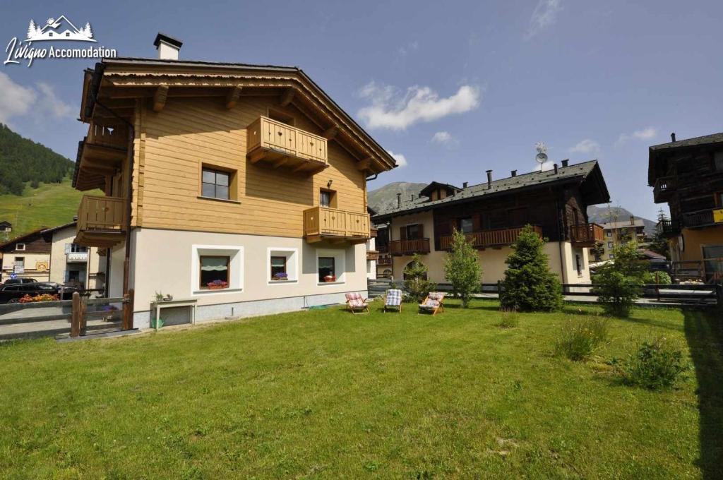 una casa con un cortile verde davanti di Abete Rosso Nuovissimo ed in centro a Livigno a Livigno