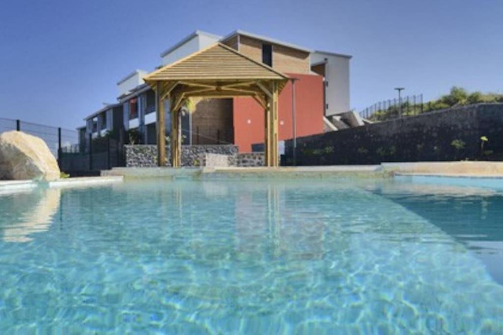 a large pool of water with a gazebo at LE LAGON La Saline Les Bains vue mer, piscine in La Saline les Bains