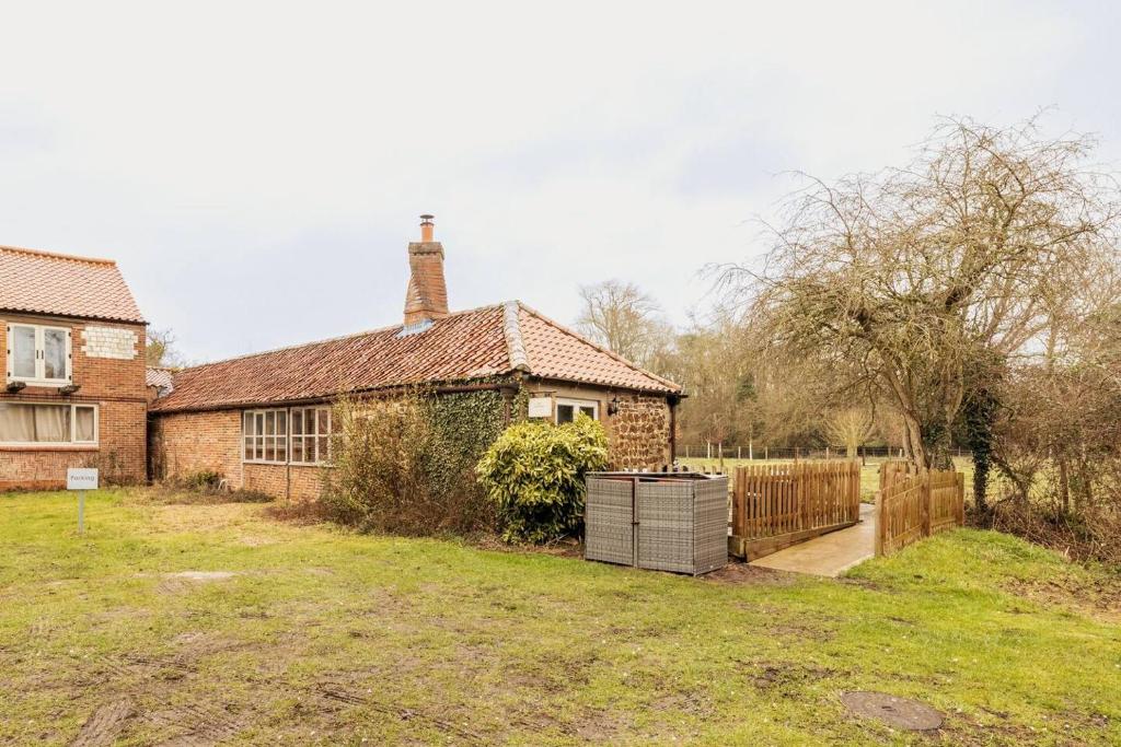 an old brick house with a fence and a yard at The Gig House - relaxing countryside spa break in Pentney