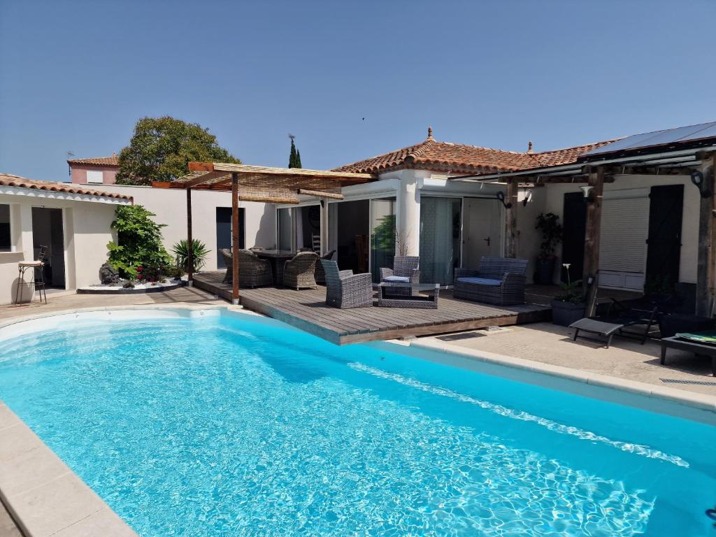 a swimming pool in front of a house at villa ORANANS in Marseillan