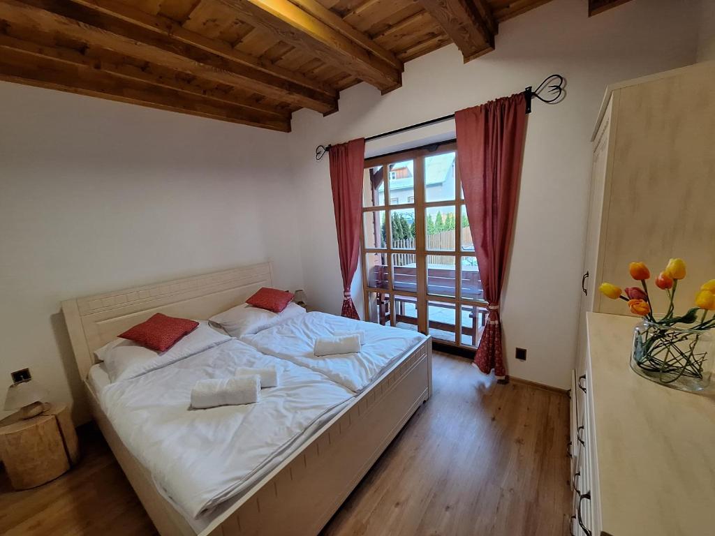 a bedroom with a bed and a large window at Apartmán Jezerné in Velké Karlovice
