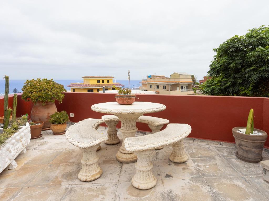 una mesa de piedra y dos bancos en un patio en Live la punta center, en Punta del Hidalgo