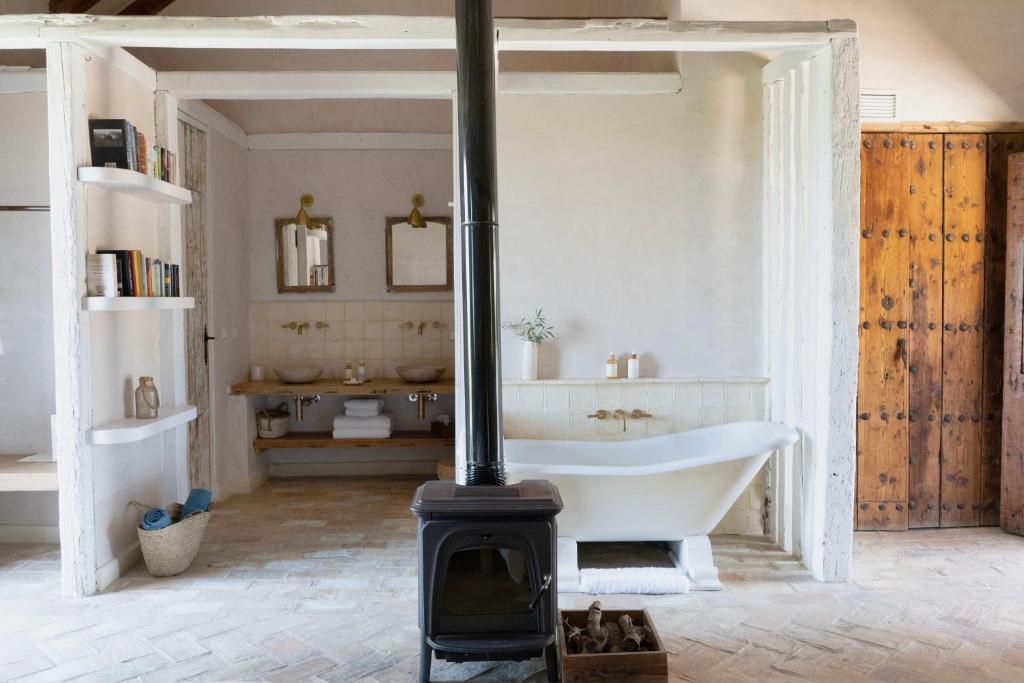 a bathroom with a fireplace and a bath tub at Casa La Siesta in Vejer de la Frontera