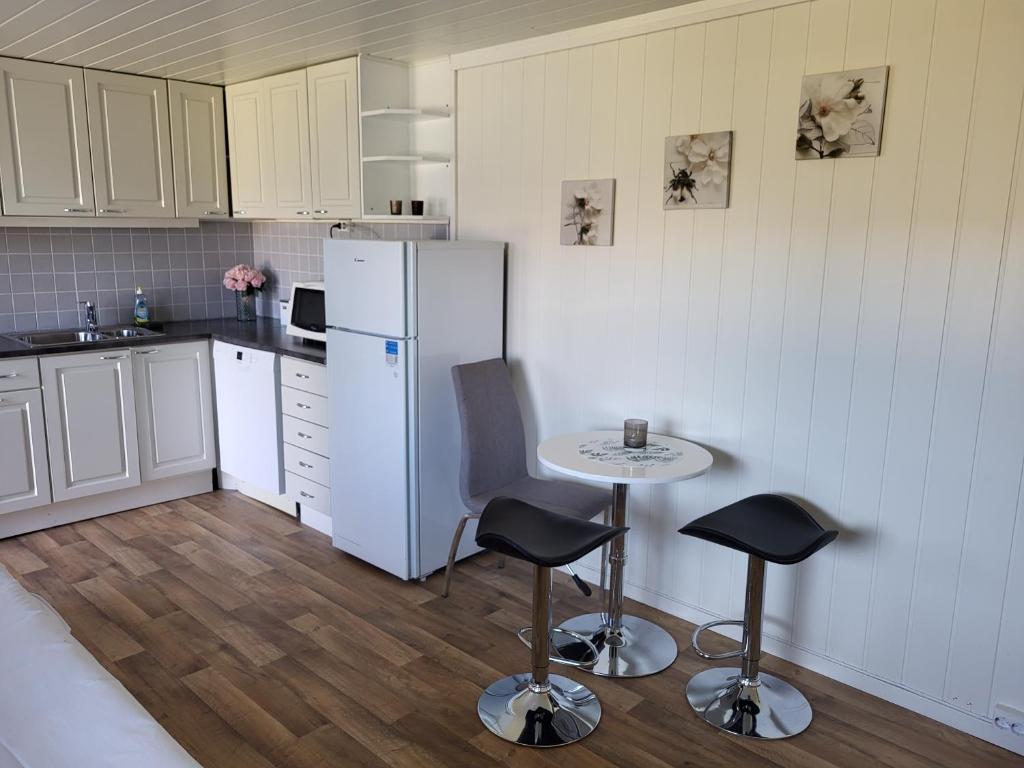 a kitchen with a white refrigerator and a table and chairs at SAGA Overnatting in Kirkenes